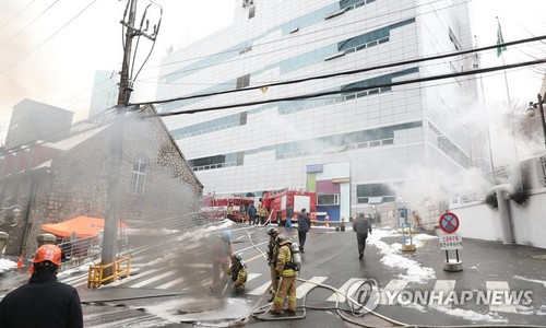 ▲ 소방대원들이 24일 오전 화재가 발생한 KT 아현빌딩 앞에서 진화작업을 진행하고 있다.