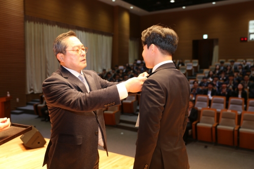구자열 LS그룹 회장(왼쪽)이 안성시 LS미래원에서 2020년 신입사원 대표에게 회사 배지를 달아주고 있다.