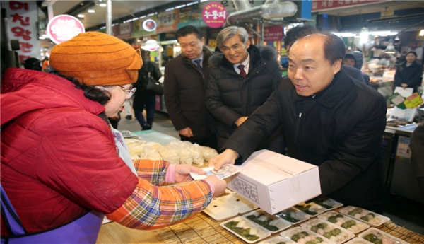 소상공인시장진흥공단 조봉환 이사장(오른쪽)이 떡국떡을 구입하고 있다.