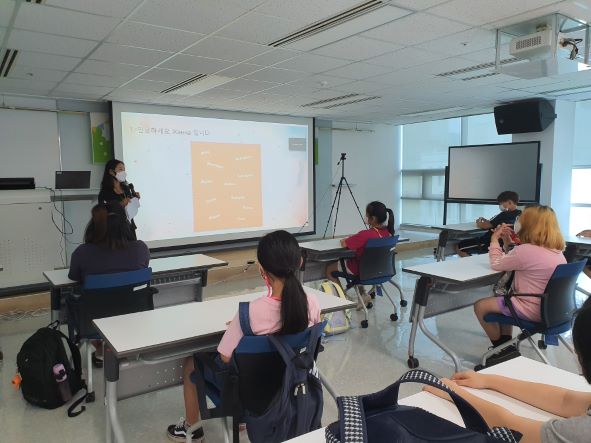 교학초등학교 학생들이 한국광해관리공단 소속 동시통역사와 함께 외국인과 화상으로 대화를 하고 있다.