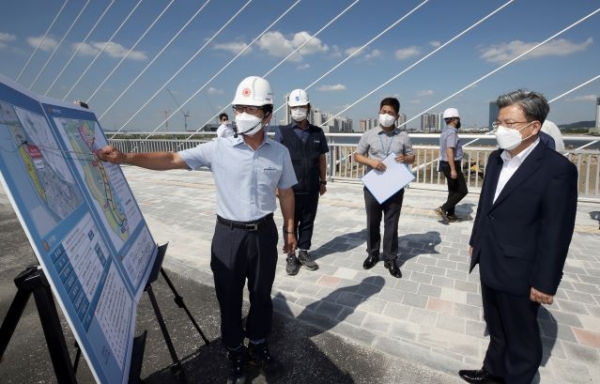 이원재 IFEZ 청장(오른쪽)이 송도국제도시 6·8공구 2단계 건설공사 현장(도로)에서 공사 관계자로부터 설명을 듣고 있다.