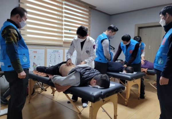 김태영박사 한국스포츠마사지자격협회장이 연천의료원과 공동으로 펼치고 있는 의료봉사 현장에서 요통환자에게 테이핑요법으로 봉사하는 모습. (사진제공=연천보건의료원)