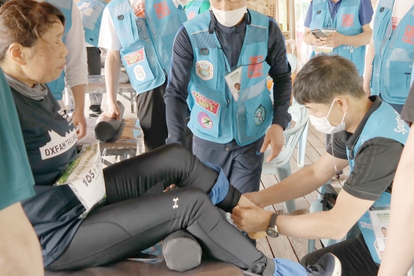 옥스팜 100km 중간지점에서 시각장애인으로 각종 마라톤대회에서 완주한 김미순 대회 참가자가 발목에 부상을 입어 김태영 박사에게 응급처치와 테이핑을 받고 있는 모습
