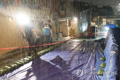 13일 폭우로 축대가 무너진 서울 서대문구 홍제천로 도로. 이로 인해 축대 아래쪽 20가구 46명이 대피했다.