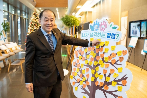 한국중부발전 김호빈 사장이 청렴나무에 청렴 메시지 스티커를 붙이고 있다,