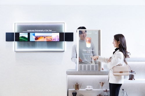 LG디스플레이 모델이 '30인치 투명 OLED'를 적용한 매장용 콘셉트를 소개하는 모습.