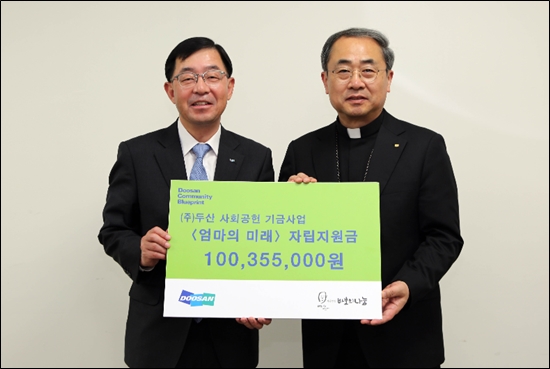 ▲ ㈜두산 박완석 부사장(왼쪽)이 재단법인 바보의나눔 손희송 이사장에게 미혼모 자립지원금을 전달하고 있다.