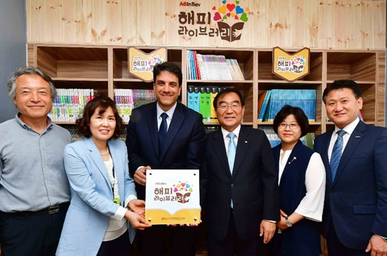 ▲ 4일 오후 충북 청주시 서원구 '행복나무지역아동센터'에서 열린 오비맥주 '해피 라이브러리' 완공 기념식에 참석한 오비맥주 및 지역아동센터 등 관계자들이 현판식에 앞서 기념 촬영을 하고 있다. 왼쪽부터 김윤모 유스투게더 대표, 신희경 행복나무지역아동센터장, 김도훈 오비맥주 사장, 이승훈 청주시장, 박영숙 지역아동센터중앙지원단장, 박제수 대교 본부장.