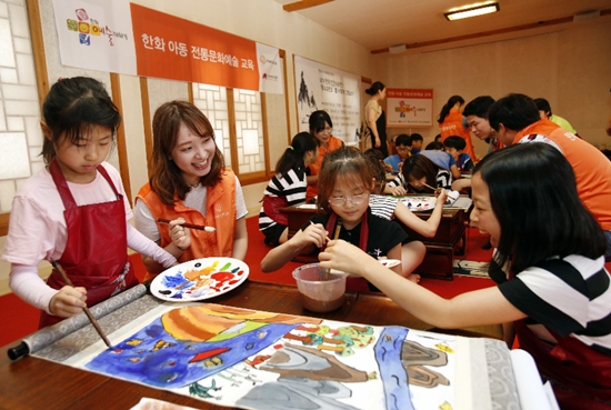▲ 한화그룹이 여름방학을 맞은 초등학생들에게 더위도 잊고 우리 전통문화도 체험할 수 있는 자리를 마련했다. 26일 서울 종로 무계원에서 초등학생들과 한화 임직원 봉사자들이 '몽유도원도'를 그리고 있다.
