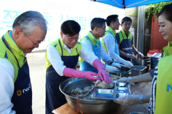 ▲ 김원규 NH투자증권 사장(왼쪽에서 두번째)과 임직원이 독거노인과 노숙인들에게 삼계탕을 배식하고 있다.