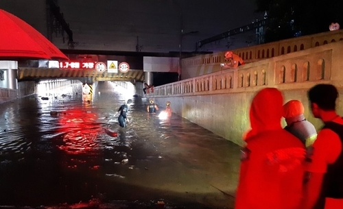 지난 23일 폭우가 내린 부산 동구 초량동 부산역 인근 제1지하차도에 출동한 소방대원들이 구조작업 중인 모습.(사진=연합뉴스)