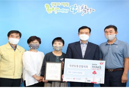 지난 18일 석관동 통장협의회 관계자들과 이승로 성북구청장(오른쪽에서 두 번째) 외 관계자들이 전달식을 마치고 기념촬영을 하고 있다.