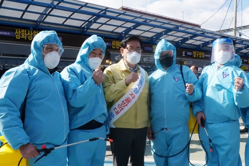 코로나19 걱정 없는 전통시장 환경을 조성하기 위해 2월부터 자율방역대를 운영하고 있는 제기동 일대 전통시장 소상공인들과 유덕열 동대문구청장(가운데)이 방역 전 기념촬영을 하고 있다.
