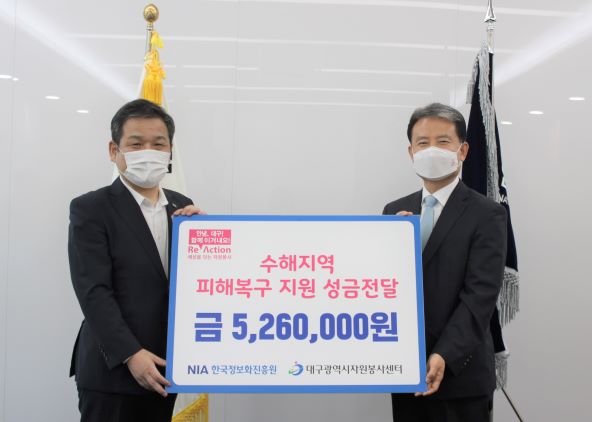 성금을 전달하는 한국정보화진흥원 문용식 원장(왼쪽)과 대구자원봉사센터 정연욱 센터장(오른쪽)
