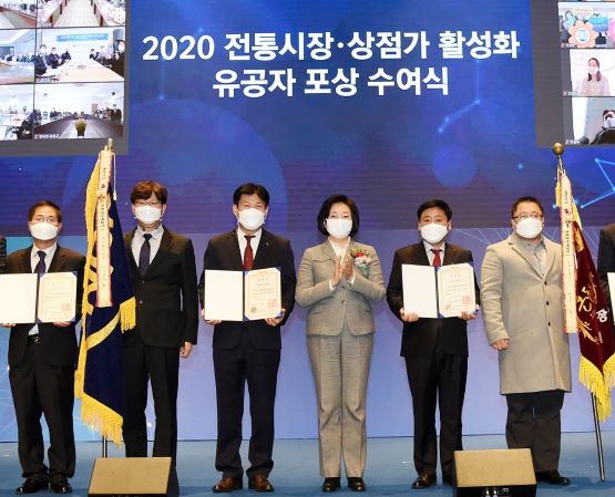 이승훈 사회적가치실현단장(왼쪽에서 세번째)이 전통시장 활성화 유공 대통령 표창 시상식에서 중소벤처기업부 박영선 장관(오른쪽에서 세번째)과 함께 기념촬영을 하고 있다.