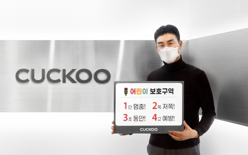 쿠쿠 구본학 대표이사가 어린이 교통안전 슬로건을 들고 기념촬영을 하고 있다