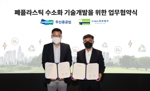분당두산타워에서 열린 '폐플라스틱 수소화 기술개발을 위한 업무협약식'에서 두산중공업 송용진 부사장(왼쪽)과 리보테크 황병직 대표이사(오른쪽)가 서명을 마친 후 기념촬영을 하고 있다.
