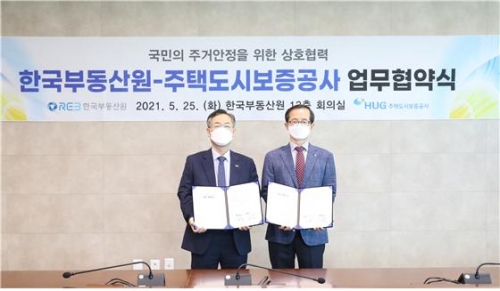한국부동산원(오른쪽 손태락 원장)과 주택도시보증공사(왼쪽 권형택 사장)가 5월 25일 업무협약(MOU) 체결 후 사진촬영을 하고 있다.