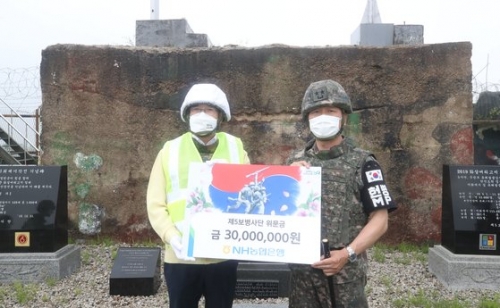 DMZ 유해발굴 현장에서 이상철 5사단장에게 위문금을 전달하는 이성희 회장. 사진= 농협
