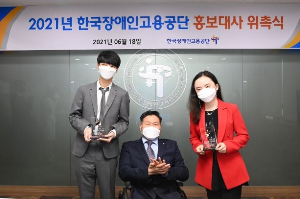 지난 18일 한국장애인고용공단은 핑거스타일 기타리스트 정성하(사진 왼쪽) 씨와, 발달장애인 기타리스트 김지희(사진 오른쪽) 씨를 공단 홍보대사로 위촉했다. 공단 조향현 이사장(사진 중앙)과 위촉패를 받은 홍보대사 정성하, 김지희 씨가 기념촬영을 하고 있다.