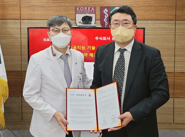 김병조 고려대학교 의료원산학협력단장(좌)과 길영준 휴이노 대표이사(우)가업무협약을 체결하고 함께 기념사진을 촬영하고 있다.