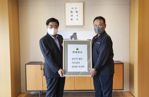 권오갑 현대중공업지주 회장이 두산인프라코어 손동연 사장에게 정주영 창업자의 경영 철학이 담긴 '현대정신' 액자를 전달하고 있다. (왼쪽부터 현대중공업지주 권오갑 회장, 두산인프라코어 손동연 사장)
