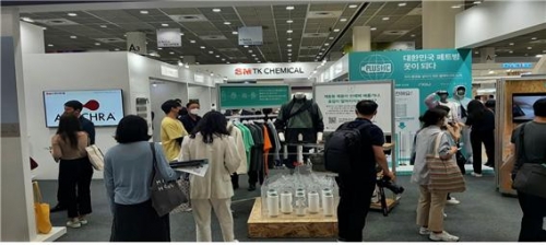 SM티케이케미칼 전시 부스를 찾은 국내외 바이어와 방문객들이 제품 설명을 듣고 있다.