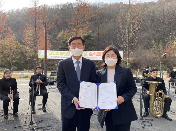 이창재(좌측) 한국산림복지진흥원장과 천성애 한빛예술단 원장이 15일 대전 유성구 숲체원로 국립대전숲체원에서 양 기관 간 업무협약서를 함께 들고 기념촬영을 하고 있다. (사진제공=산림청 한국산림복지진흥원)