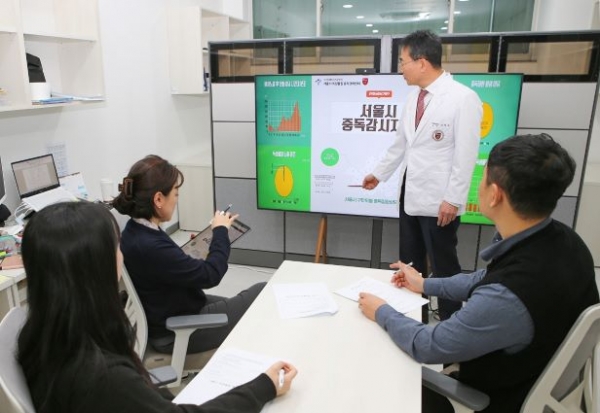 고대안암병원 서울시 독성물질 중독관리센터 이성우 센터장(화면 앞에서 설명하는 분)과 연구원들이 중독감시체계 구축 관련 회의를 진행하고 있다.
