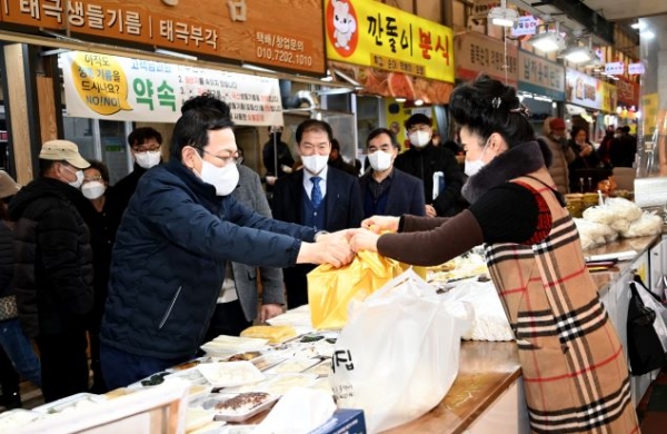 박남춘 인천광역시장(왼쪽)이 27일 2022년 설 명절맞이 민생현장 방문으로 미추홀구 용현시장을 방문해 상인들을 격려하고 물품을 구매하고 있다.