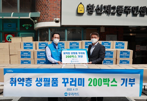 이달 21일 서울 종로구 창신2동에서 진행된 생필품 기부 행사에서 김정기 우리카드 사장(왼쪽)과 전경표 창신2동장이 기념사진을 촬영하고 있다. [사진=우리카드 제공]