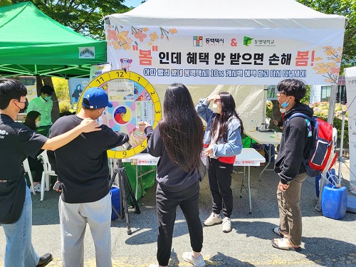 지난 4일 동명대학교 안에 설치된 동백택시 홍보부스에서 학생들이 추첨 이벤트에 참여하고 있다. [사진=코나아이 제공]
