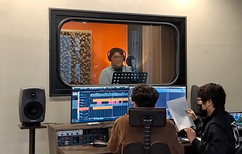 지난달 열린 우리카드 'NU 그린콘서트' 참여를 위해 사내 임직원 가수(가운데 헤드셋 착용한 사람)가 음원 녹음을 하고 있다. [사진=우리카드 제공]