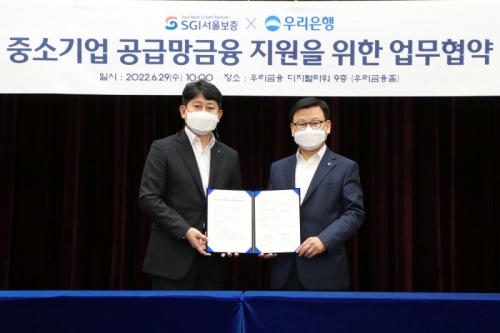 이원덕 우리은행장(오른쪽)과 유광열 SGI서울보증 대표이사가 관계자들과 기념촬영을 하고 있다.