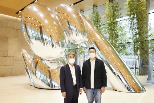 윤종원 기업은행장(왼쪽)이 강재원 작가와 기업은행 본점 로비에서 기념사진을 찍고 있다.