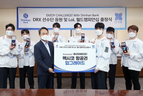 신한은행 진옥동 은행장(왼쪽 세번째)과 DRX 리그오브레전드팀 데프트(Deft)선수(오른쪽 세번째)를 비롯한 DRX 소속 e스포츠 선수들이 기념촬영하는 모습.