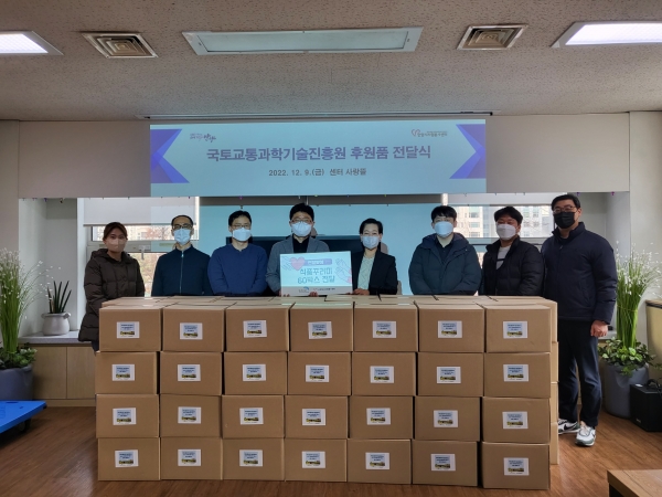 국토교통과학기술진흥원(국토교통진흥원) 임직원이 안양시자원봉사센터 관계자에게 식품꾸러미를 전달 하고 있다.
