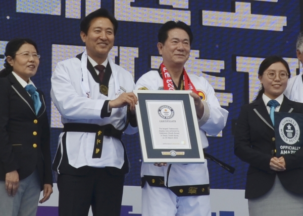 세계기네스연맹 관계자로부터 태권도 태극1장 단체 시연을 통해 기네스기록 갱신에 성공했음을 인정받고 오세훈 서울시장(좌측)과 이동섭 국기원장(우측)이 기네스 기록증서를 들어보이고 있다.