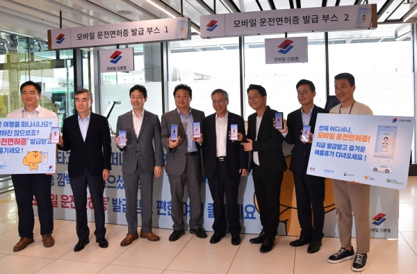 8월 9일 도로교통공단과 한국조폐공사가 김포공항 국내선 청사에서 '찾아가는 모바일 운전면허증 무료 발급 행사'를 실시하고 기념사진을 촬영하고 있다. (왼쪽부터 한국조폐공사 천재웅 차장, 도로교통공단 김진표 운전면허본부장, 한국공항공사 윤형중 사장, 행정안전부 서보람 디지털정부국장, 한국조폐공사 반장식 사장, 개그맨 김준호씨, 경찰청 이서영 교통기획과장, 도로교통공단 배준호 과장) (사진제공=도로교통공단)
