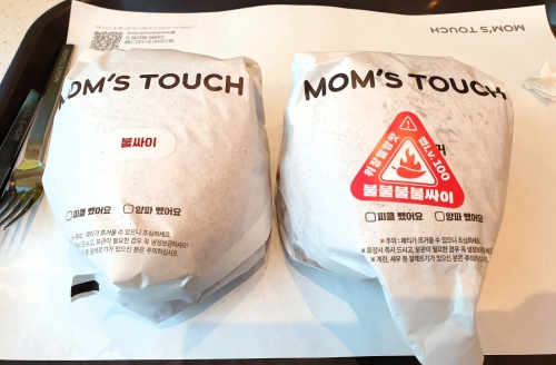 불싸이버거(왼쪽)와 불불불불싸이버거. 불불불불싸이버거 포장지에는 주의 스티커가 붙어 있다. [사진 = 안솔지 기자]