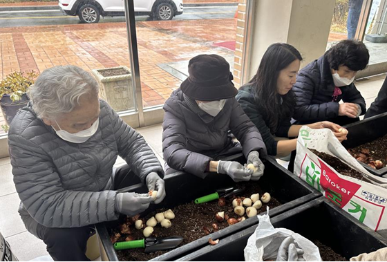 27일 경기도 부천 공공임대아파트(범박 휴먼시아 1단지)에서 진행된 '생활숲 사회통합형 산림복지서비스 시범사업'의 참여자들이 단지에 설치될 대형 화분에 구근심기 활동을 하고 있다. (사진제공=한국산림복지진흥원)