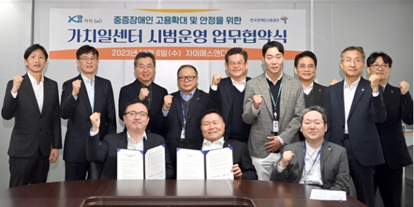 한국장애인고용공단 조향현 이사장(우)과 자이에스앤디 엄관석 대표이사(좌)는 협약서에 서명 후 행사에 참석한 관계자들과 함께 기념촬영을 하고 있다.