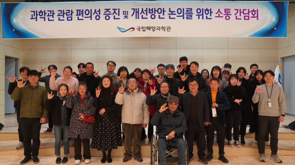 '사랑해' 라는 의미의 수어를 사용하여 단체 촬영을 하고 있다.