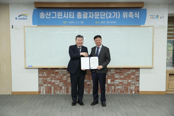 안정호 한국수자원공사 그린인프라부문장(사진 왼쪽)이 3월 5일 송산그린시티 제2기 총괄자문단의 총괄기획가인 김찬호 중앙대 교수(사진 오른쪽)에 위촉장을 건네며 총괄자문단 출범을 기념하고 있다.이날 행사는 송산그린시티를 최신 트렌드를 반영한 명품도시로 조성하기 위해 총괄기획가인 중앙대학교 김찬호 교수를 중심으로 도시계획 및 설계, 건축, 탄소중립, 교통, 마케팅 등 총 6개 분야 13명의 전문가로 구성된 제2기 총괄자문단을 출범하고 실행력 있는 운영방안을 논의하기 위해 마련됐다.