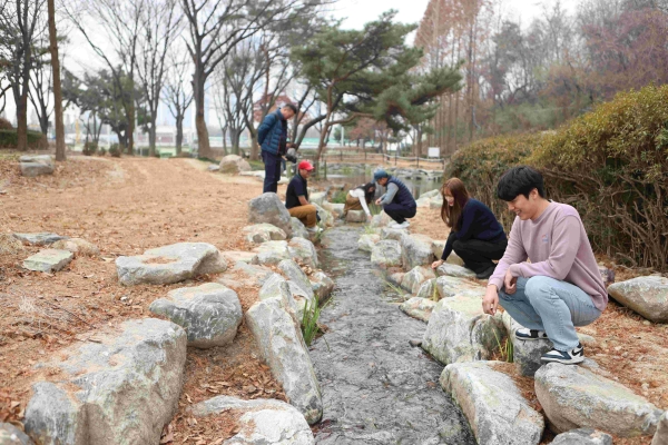 인천환경공단 직원들이 인천둘레길 9코스 주변에 개방한 실개천형 연못을 둘러보고 있다.