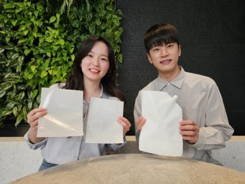 SK지오센트릭 구성원들이 SK지오센트릭의 단일 플라스틱 소재로 율촌화학이 제조한 포장재 시제품을 소개하고 있다.[사진=SK지오센트릭]