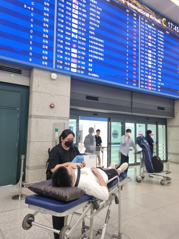 25일 환자이송침대에 실려 인천국제공항 입국장에 들어서는 백씨 모습(사진제공=성남시)