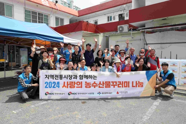 한국석유공사 자원봉사단과 태화시장 상인들이 지역 홀몸어르신에게 전달할 농수산물 꾸러미를 포장하고 기념촬영을 하고 있다.