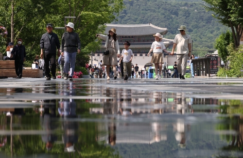 더운 날씨를 보인 지난 29일 오후 서울 광화문 광장에서 시민들이 걸어가고 있다. 사진=연합뉴스
