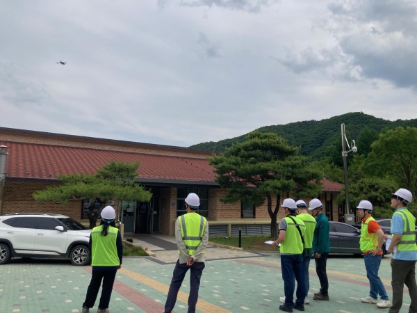 한국산림복지진흥원 합동 점검반원이 국립산림치유원에서 드론(좌측 상단)을 활용해 접근이 어려운 건축물 지붕부를 점검하고 있다. (사진제공=한국산림복지진흥원)